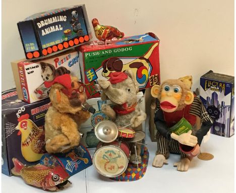 A box of various vintage toys and games to include a Cragstan crapshooter monkey clockwork toy, an Alps (Japanese) battery op