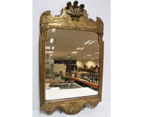 An 18th Century carved giltwood and gesso framed wall mirror, the Vauxhall plate within a foliate and floral decorated frame 