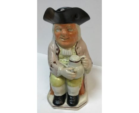 A 19th Century Staffordshire pottery Toby jug as "Toby Philpott seated with jug of ale on his left knee, a pipe in his right 