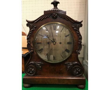 A 19th Century mahogany cased mantel clock with applied moulded scrolling foliate decoration, the eight-day movement with sil