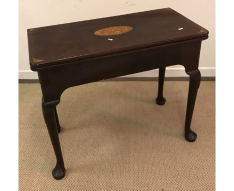 An early George III mahogany card table, the later fan marquetry and conch shell inlaid top opening to reveal a baize-lined i