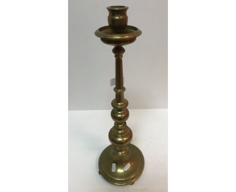 An early 20th Century brass candlestick in the 18th Century manner, the candle holder with drip tray, raised on a turned pede