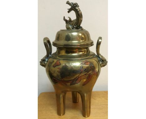 A Chinese brass lidded censer, the lid with dragon finial, the base set with twin handles and lion masks and tri coloured flo