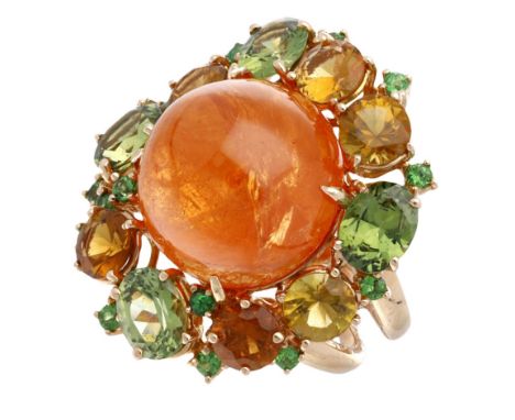 A garnet cluster ring, the circular spessartine garnet cabochon within a cluster surround of circular and oval mixed-cut gree