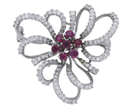 A ruby and diamond brooch, comprising a circular-cut ruby cluster within a surround of pierced brilliant-cut diamond set scro