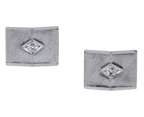 A pair of diamond cufflinks, the pyramidal plaques with a brushed satin finish, the central brilliant-cut diamond highlight i