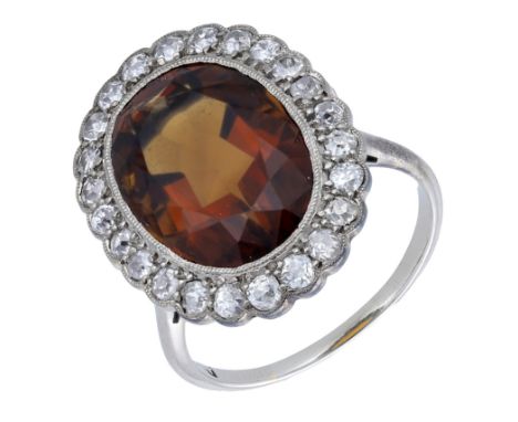 A smoky quartz and diamond cluster ring, first half of 20th century, set with an oval-cut smoky quartz within a surround of o