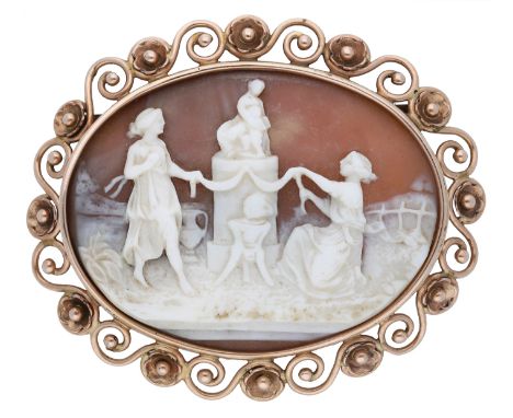 A late 19th/early 20th century shell cameo brooch/pendant, the oval cameo carved to depict vestal virgins dancing before a mo
