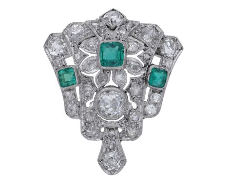 An Art Deco emerald and diamond clip, the tapering clip with foliate detailing and set with three step-cut emeralds, within a