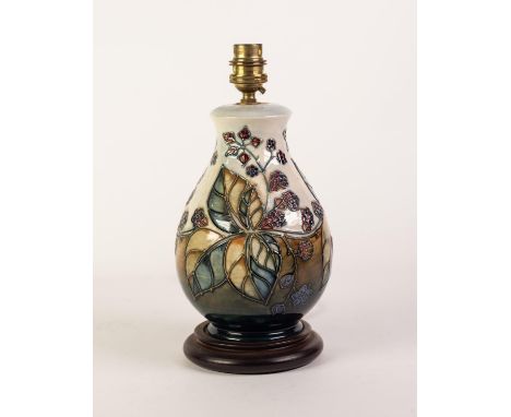 MODERN MOORCROFT POTTERY SWOLLEN BALUSTER SHAPE ELECTRIC TABLE LAMP with wooden base, tube lined with berried branches, 11in 