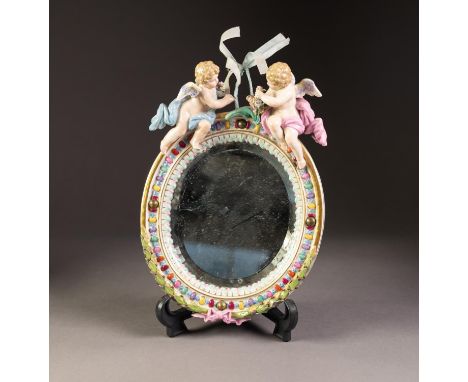 EARLY TWENTIETH CENTURY DRESDEN MOULDED PORCELAIN SMALL MIRROR, the oval, bevel edged plate in a moulded frame painted with j