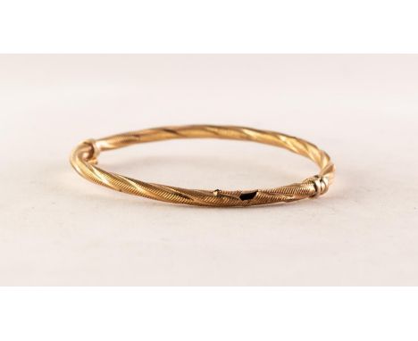 9ct GOLD HINGE OPENING HOLLOW BANGLE of spirally twisted and engraved form, 4.2 gms 