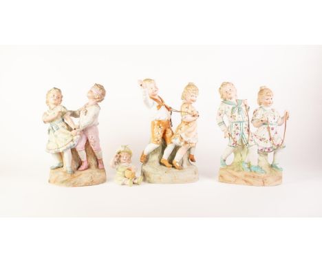 THREE TINTED BISQUE GROUPS OF CHILDREN PLAYING, unmarked, 12? (30.5cm) high and smaller, together with a SMALL TINTED BISQUE 