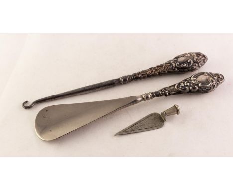 SHOEHORN AND A BUTTON HOOK, each with an Edwardian silver handle repousse with rococo scrolls, Chester 1905 and Birmingham 19
