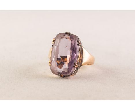 GOLD COLOURED METAL RING with an oval amethyst, in six claw setting, 4.8 gms 