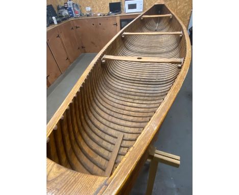 An early 20th century Canadian cedar strip canoe of traditional construction with three seats, one with mast hole, brass moun