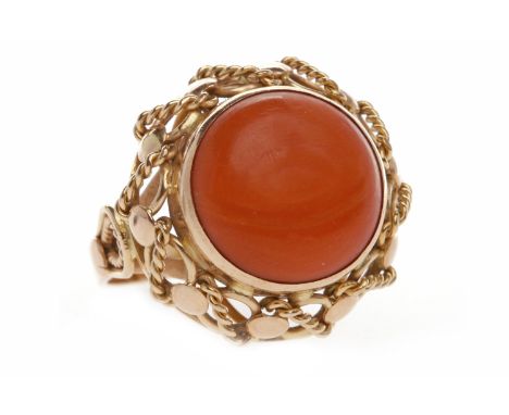 NINE CARAT GOLD CORAL RINGset with a large circular section of coral 14mm diameter, tall openwork gallery, size R, 8.2g
