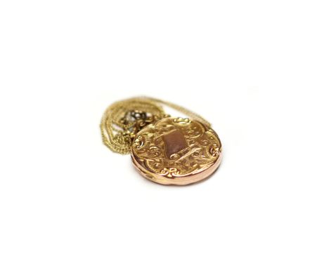 NINE CARAT GOLD LOCKETof circular form, with engraved scrolling decoration and moulded border, 25mm diameter, on a rolled gol