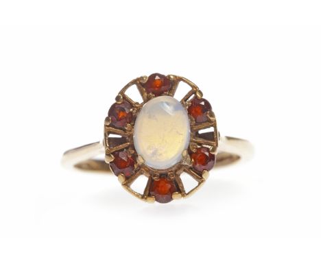 NINE CARAT GOLD GEM SET RINGset with a central oval cabochon cut section of opalescent glass within a pierced border set with
