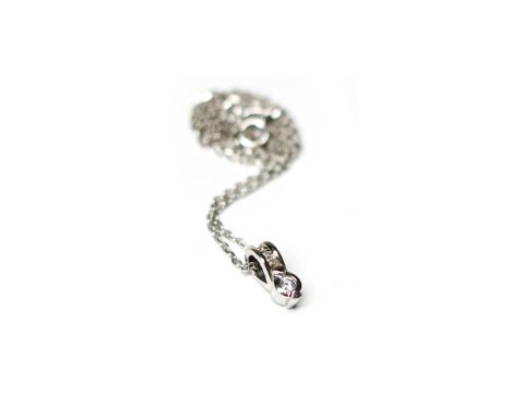 EIGHTEEN CARAT WHITE GOLD DIAMOND PENDANT ON CHAINset with a single round brilliant cut diamond below a row of smaller round 