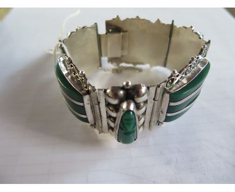 A very good quality silver and green stone bracelet - the upright stones carved into faces - internal diameter 19cm - weight 