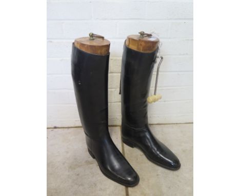 A pair of black leather riding boots by Harrods with wooden boot trees - Size 10 1/2 - stitching is brittle but ideal as prop