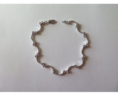 A 9ct white gold and diamond ladies bracelet set with twenty-six small round cut diamonds in collett setting with curved soli