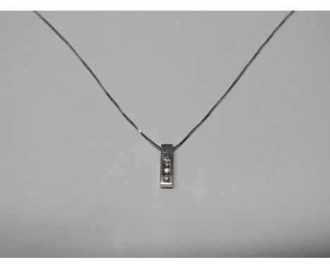 A modern 9ct white gold and diamond pendant on chain - the pendant set with three small diamonds, the box chain measures 38cm