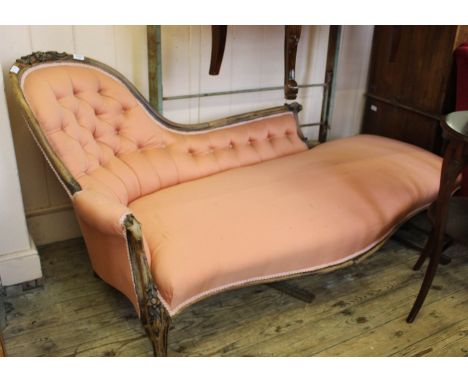 A Victorian carved mahogany chaise longue with salmon pink button back upholstery