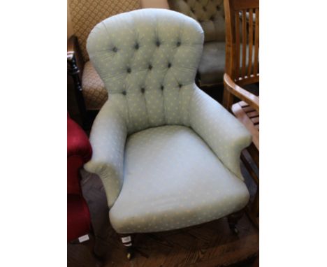 A Victorian carved mahogany button back armchair 