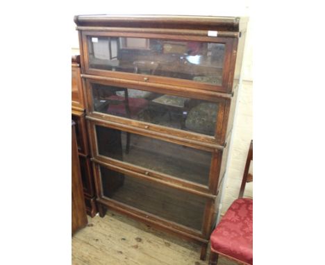 An oak Globe Wernicke four tiered glazed bookcase on stand