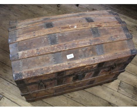 A vintage domed top metal bound pine and canvas trunk