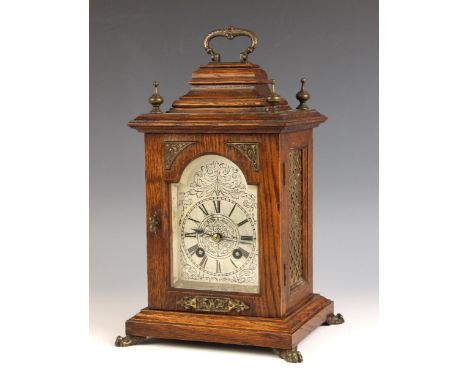 A late 19th century oak cased Lenzkirch mantle clock, the case with brass swing handle and finials above the 8cm silvered bre