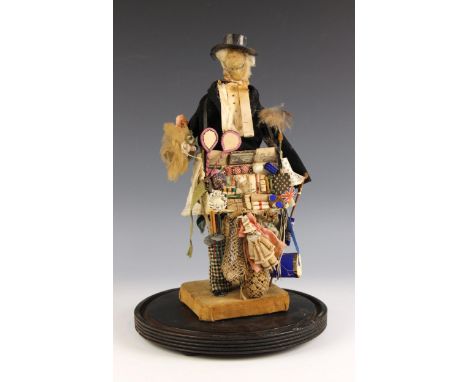 A Victorian male pedlar doll, late 19th century, the beeswax head with painted eyes and spectacles, the doll dressed in check