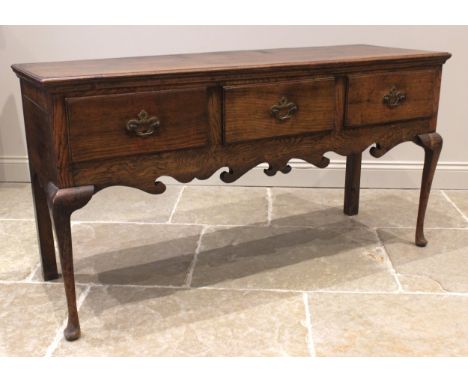 A George III style Shropshire type oak dresser, 20th century, the enclosed plate rack with a moulded cornice over a wavy frie
