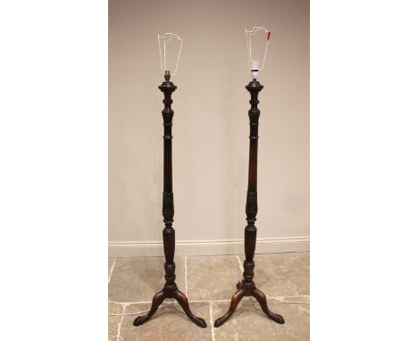 A pair of Georgian style mahogany standard lamps, early 20th century, each with a reeded and tapering column extending to thr