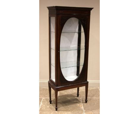 An Edwardian mahogany display cabinet, the moulded simulated dentil cornice over an inlaid frieze and a single door, the glas