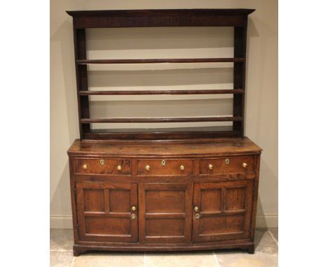 A George III oak Welsh dresser, probably North Wales, the open plate rack with a moulded cornice and plain frieze over three 
