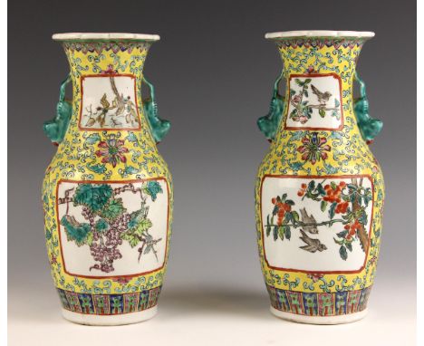 A pair of Chinese porcelain famille jaune vases, each of baluster form and decorated with two panels of birds and fruiting sp