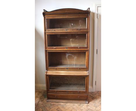 An early 20th century oak Globe-Wernike type four tier sectional bookcase, the cornice with an arched rear gallery and dentil