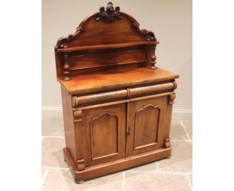 A Victorian mahogany chiffonier, the arched shelf back with moulded foliate and 'C' scroll detail, over a pair of half cylind