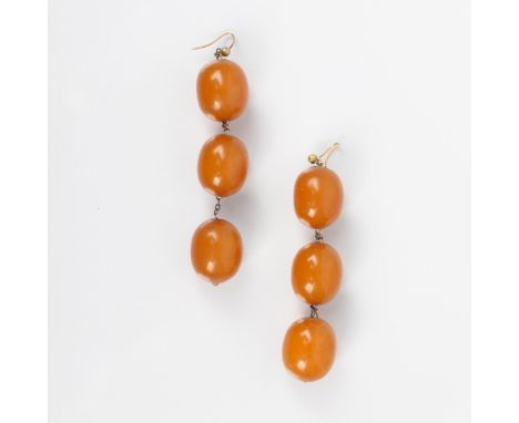 A pair of butterscotch coloured 'amber' bead earrings, the three barrel shaped beads suspending upon trace link chain, with s
