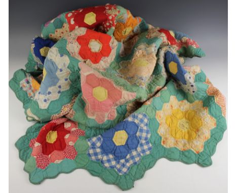 A vintage hexagonal quilt, early 20th century, formed of geometric floral motifs against a green ground, on one piece backing