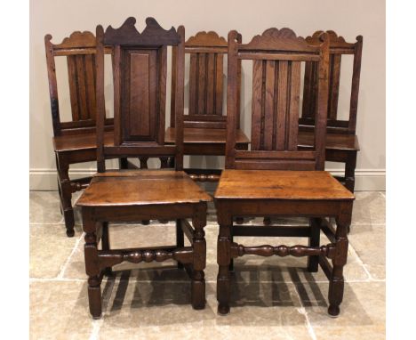 A matched set of five (4+1) 18th century and later oak dining chairs, each with a shaped pediment and panel back over a board