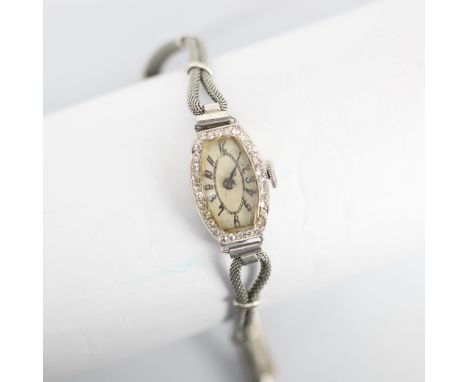 An Art Deco ladies diamond cocktail wristwatch, the tonneau shaped dial with Arabic numerals, within a mixed cut diamond surr