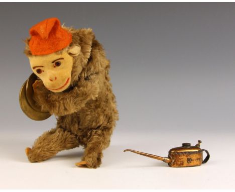 A Meccano model 'K' miniature railway engineer's oil can, 20th century, 11cm long; with a plush covered clockwork toy monkey 