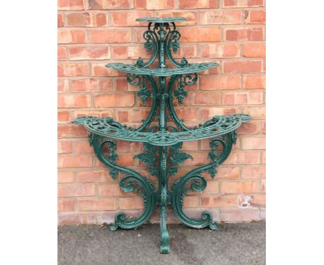 A Victorian style painted cast metal plant stand, formed with an upper tier over two graduated crescent shaped tiers, all upo