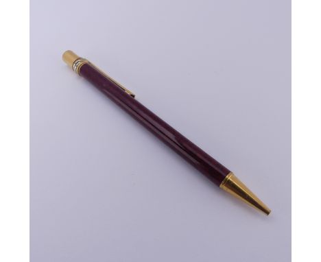 A Must de Cartier ballpoint Pen,&nbsp;the red marbled barrel with gold plated mounts and twist mechanism,&nbsp;ref. 860139, n