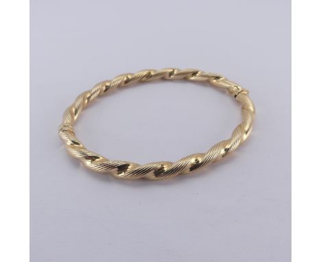 A 9ct yellow gold hollow hinged Bangle, of twisted reeded design, internal diameter at widest, 6.3cm, 10.5g.