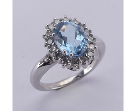 An aquamarine and diamond cluster Ring, the oval facetted aquamarine approx. 9.68mm long, within a surround of sixteen circul